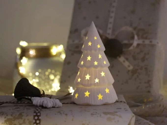Árbol de Navidad blanco con perforaciones en forma de estrellas; incluye velita LED de luz cálida