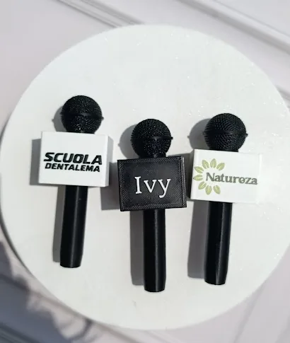 Tres adaptadores de micrófono personalizados con diferentes nombres y logos en colores blanco, negro y verde