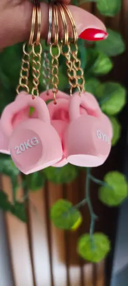 Llaveros rosados en forma de pesa rusa con argollas y cadenas doradas